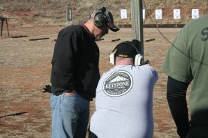 Sheriff Jim Bauman, who specializes in firearms, overlooks a cadet on the gun range.