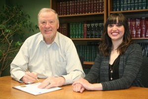 Mayor Chuck Burtcher signs the Child Abuse Prevention Month proclamation with Amanda Fortney.