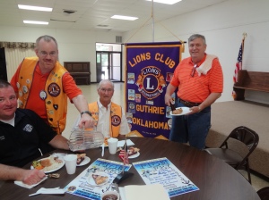 Lions preparing for Fantastic Fish Fry. Fire Chief Eric Harlow (L) and Lion Jim Morton (third from left) are served by Lion President John Wood (second rom left) and Fish Fry Chairman, Richard Ireton (far right) as they prepare to the annual Lions Fish Fry on Friday, August 15.